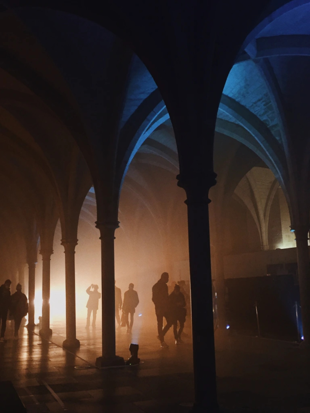 La nef du collège des Bernardins est baignée dans une lumière jaune et bleue, éclairé par Jérôme Baudouin, créateur lumière en danse, théâtre et spectacle vivant.